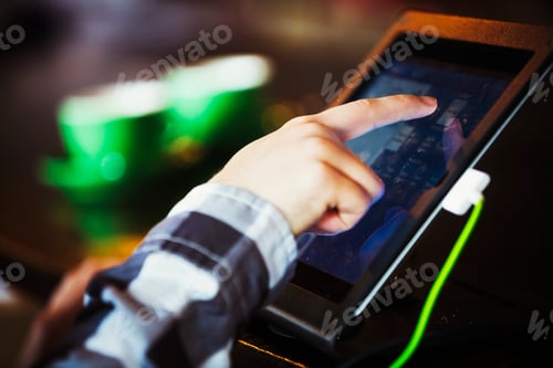 Preview: Specialist coffee shop. A person using a touch screen at a till.