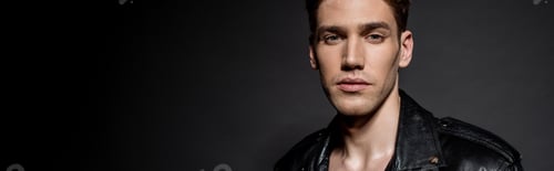 Preview: sexy young man in biker jacket on black background, panoramic shot