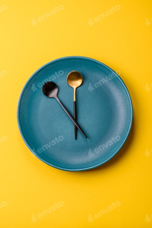 Preview: Empty plate with devices in the form of clock hands as a conceptual background for lunch time