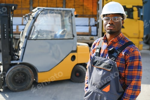 Preview: Portrait of a happy African American male worker driving forklift at workplace