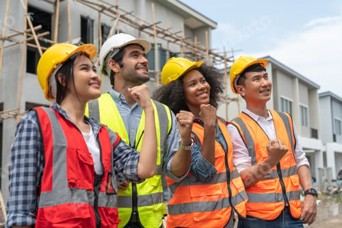 Preview: Teamwork civil engineers and architect standing raising fist at housing estate construction site