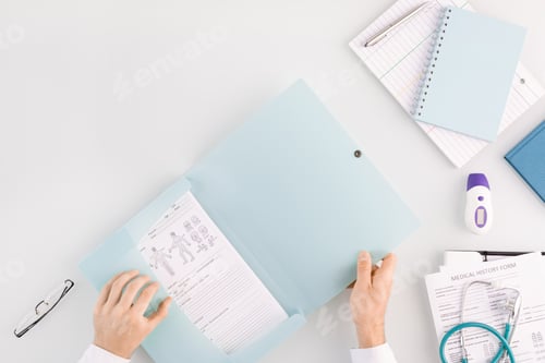 Preview: Hands of doctor opening folder with medical document while going to take it out