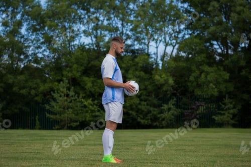 Preview: Football player holding soccer in the ground