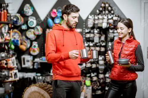 Preview: Couple choosing camping dishes in the shop