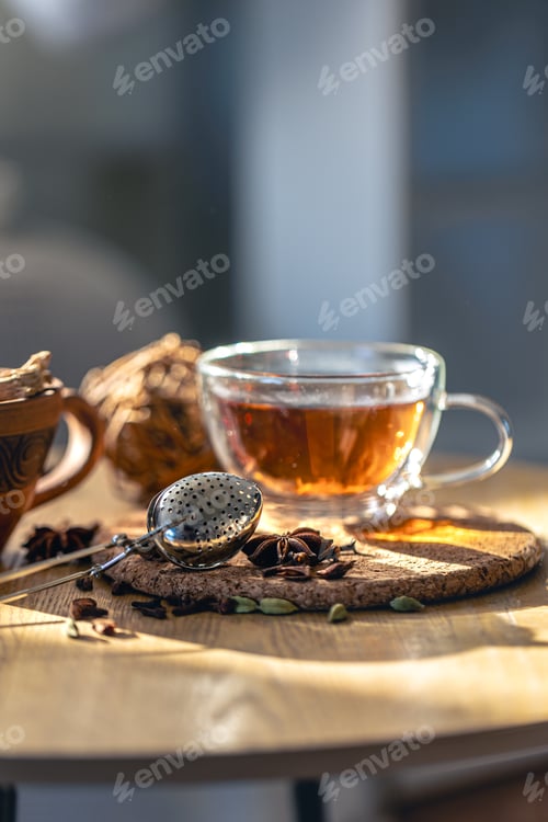 Preview: Tea ceremony, glass cup of black tea and teapot on blurred home background.
