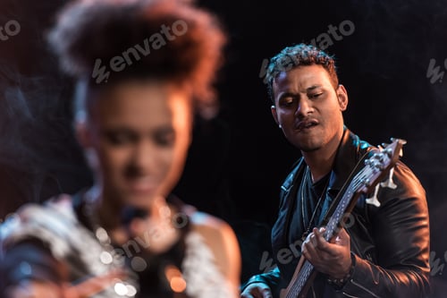 Preview: Young electric guitar player performing hard rock music with singer on stage