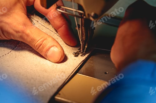 Preview: Professional leatherworker making a leather clothing with a sewing machine