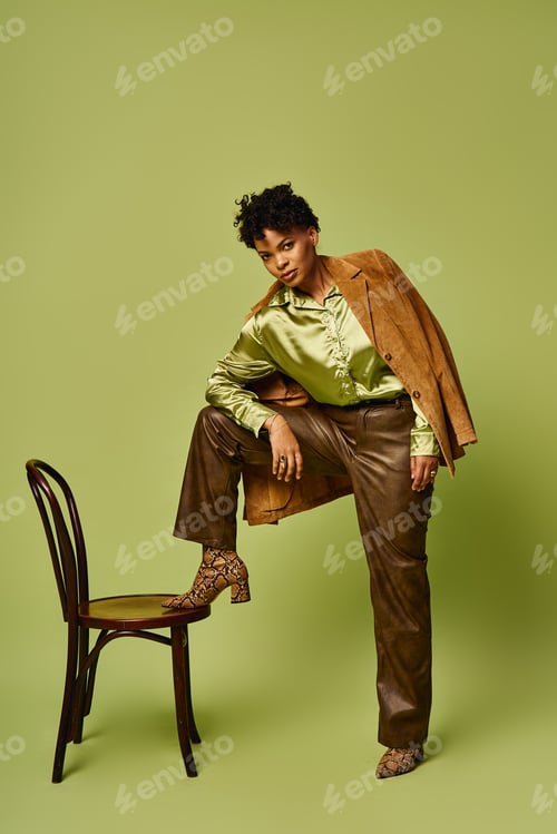 Preview: Stylish african american woman posing confidently against a vibrant green background