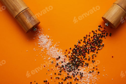 Preview: top view of spice containers and salt with peppercorns on orange