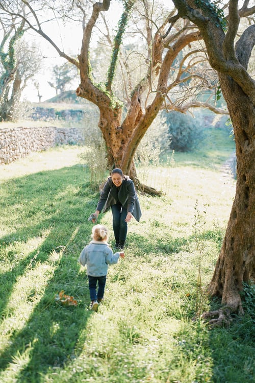 Preview: Little girl runs through the park to her mother who has opened her arms. Back view
