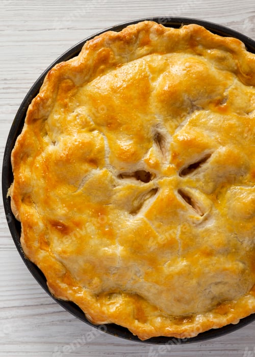 Preview: Homemade apple pie on a white wooden table, top view. Flat lay, overhead, from above. Close-up.