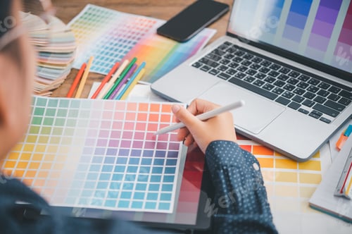 Preview: Graphic designer architects who work with laptops and color comparison tables for design work.