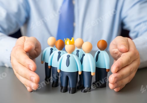 Preview: A businessman holds a group of employee figurines in his arms. A united business team