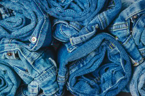 Preview: A Collection of Rolled Denim Jeans Showcasing Various Shades and Styles of Blue Textile Fabric