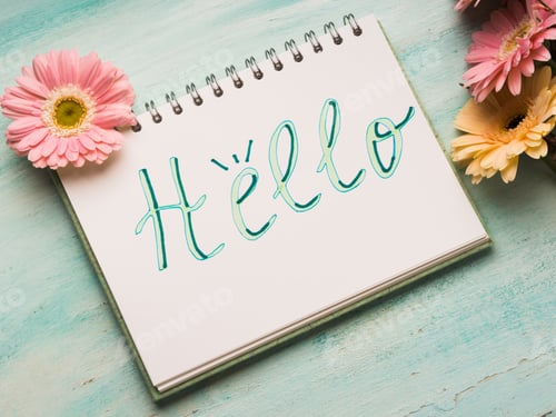 Preview: Hello word written on notebook page. Flowers