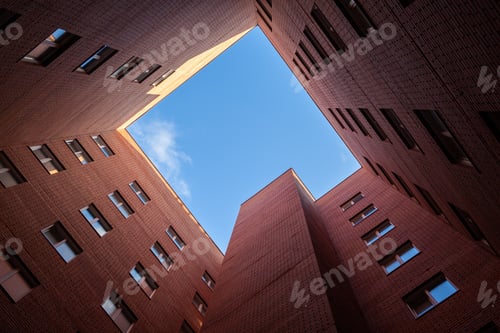 Preview: Brick high-rise new square house on a blue sky background.
