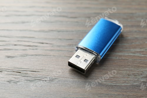 Preview: One flash drive on wooden background, closeup. Space for text
