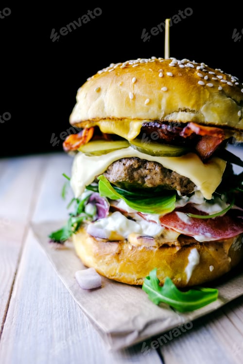 Preview: Appetizing cheeseburger on wooden table.