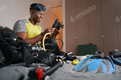 Preview: Cheerful man smiling while working with scuba set