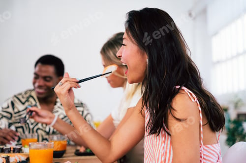 Preview: Multiethnic group of young friends meeting at home and eating sushi