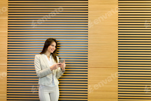 Preview: Young woman with mobile phone in the office