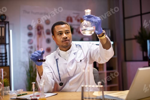 Preview: Modern medical research laboratory: african american male scientist working with flask
