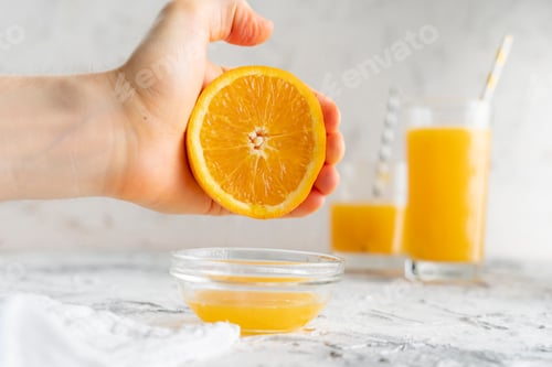 Preview: person squeeze fresh orange juice with a bare hand, healthy drink in a glasss