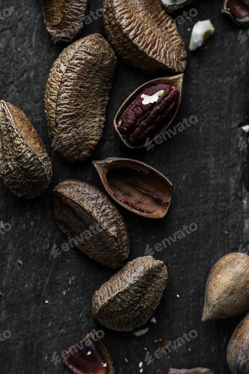 Preview: Raw Brazil and Pecan nuts in shell on Wooden Rustic table.