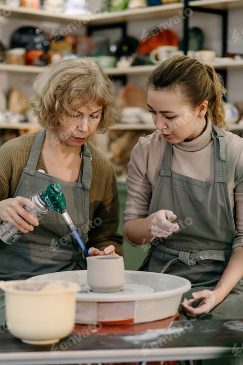 Preview: Mentor teaches pottery fundamentals, demonstrating sculpting skills on wheel