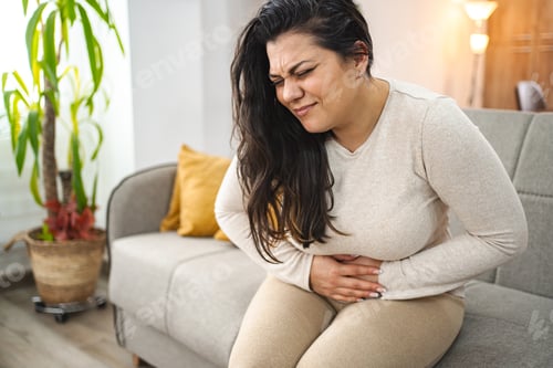 Preview: Woman experiencing painful stomachache at home