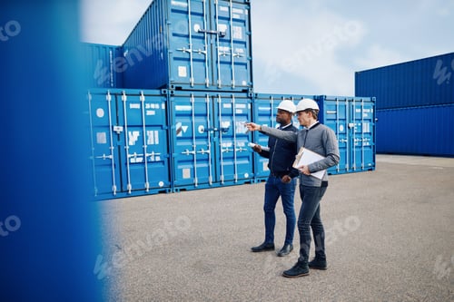 Preview: Two engineers tracking shipping inventory in a freight container yard