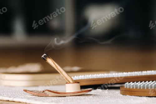 Preview: A smoking Palo Santo stick and boards with nails for yoga classes