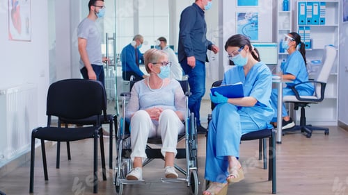 Preview: Nurse taking notes from disabled senier patient