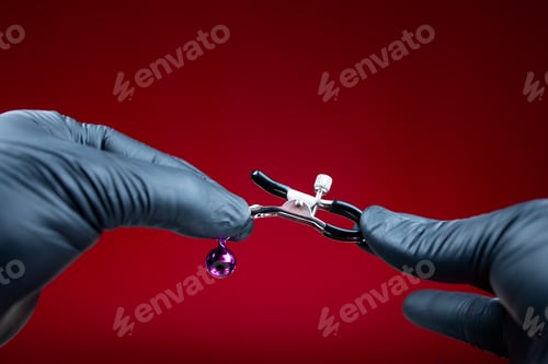 Preview: hands in black gloves holding nipple clamps for a woman for sexual bdsm games