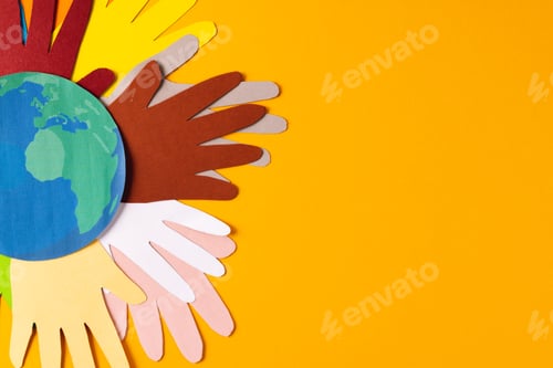 Preview: Paper cut out of multi coloured hands and globe with copy space on yellow background