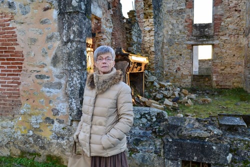 French woman on the ruins of the ruined city Oradour-sur-glan in France