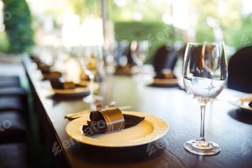 Preview: Sparkling glassware stands on long table prepared for wedding dinner.