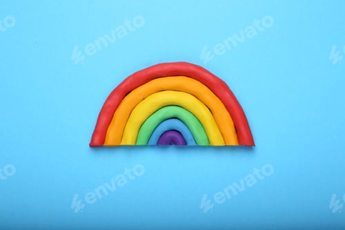 Preview: Beautiful rainbow made of plasticine on light blue background, top view