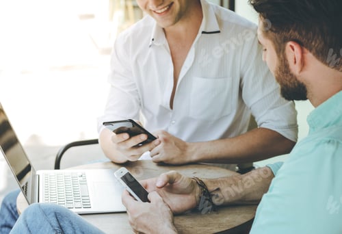 Preview: Two business men using smartphone and laptop in the cafe