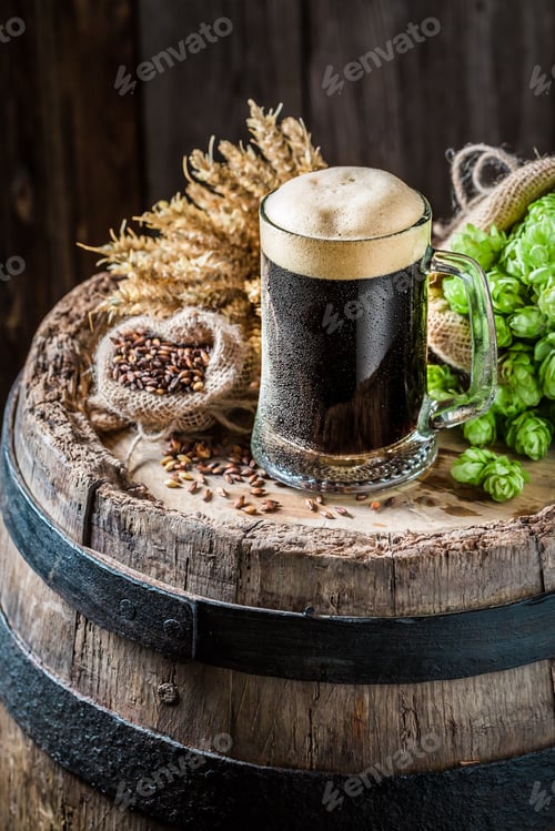 Preview: Cold dark beer on oak barrel with hops and wheat