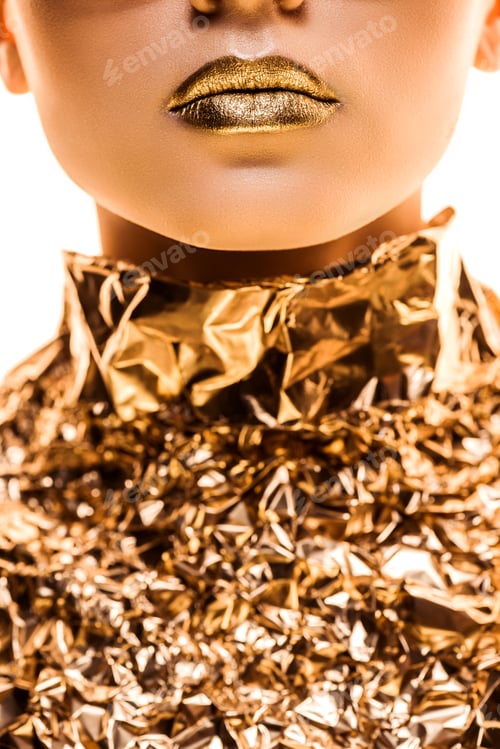 Preview: partial view of young woman with golden lips in golden foil isolated on white