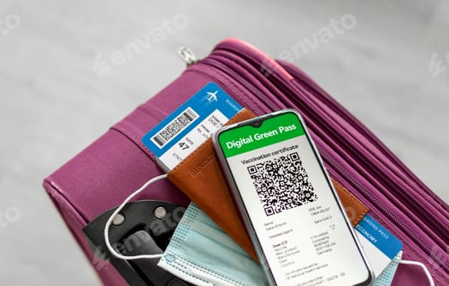Preview: Close-up top view image mobile phone with covid pass, passport and boarding pass on suitcase.