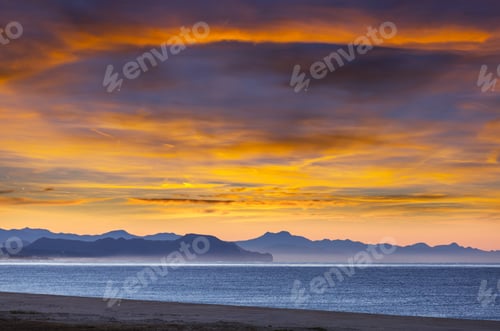 Dramatic Sunrise Sky over Sea and Mountains