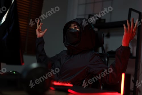 Preview: Hacker in hoodie raising hands while having problem with hacking programming system or server