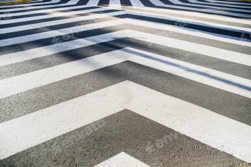 Preview: White converging lines on a black asphalt background in an unusual crosswalk.