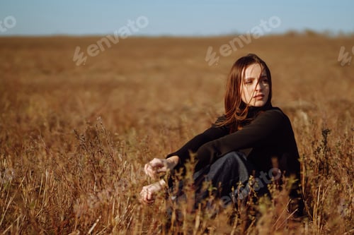 Preview: Young woman in stylish clothes posing in autumn field. Nature, fashion, lifestyle. Travel.