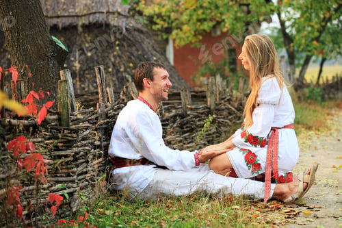 Preview: Lovely couple in Ukrainian style clothing flirting outdoors