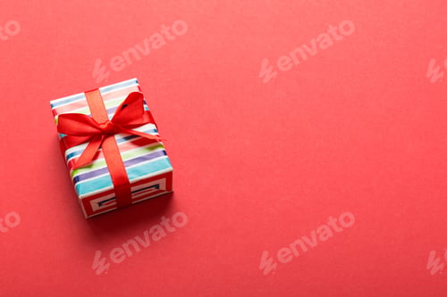 Preview: Wrapped christmas or other holiday handmade present in paper with colored ribbon. Present box