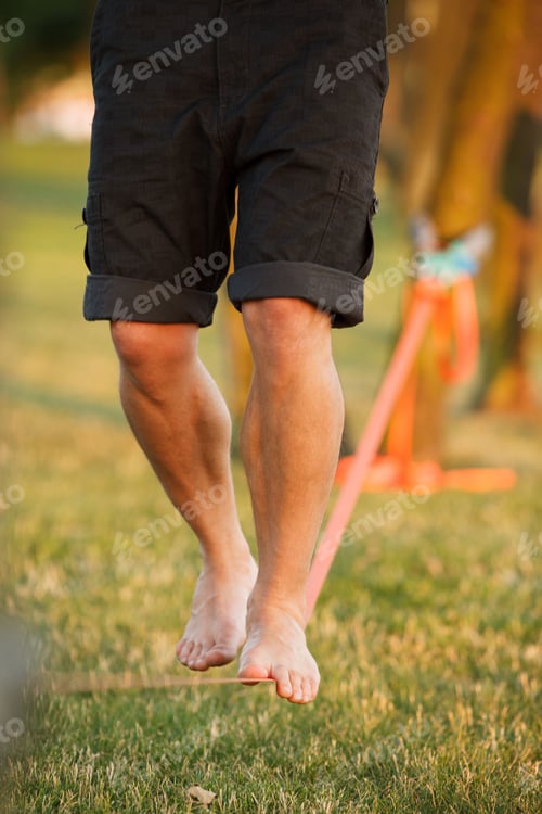 Preview: Vertical barefoot person walking on a slackline, slacklining in the daytime, the concept of balance