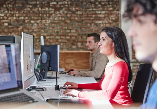 Preview: Mature woman working in office with young colleagues